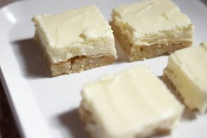 These lemon cheesecake bars only take four ingredients! With a sugar cookie crust it's sweet and tangy and everyone loves it.