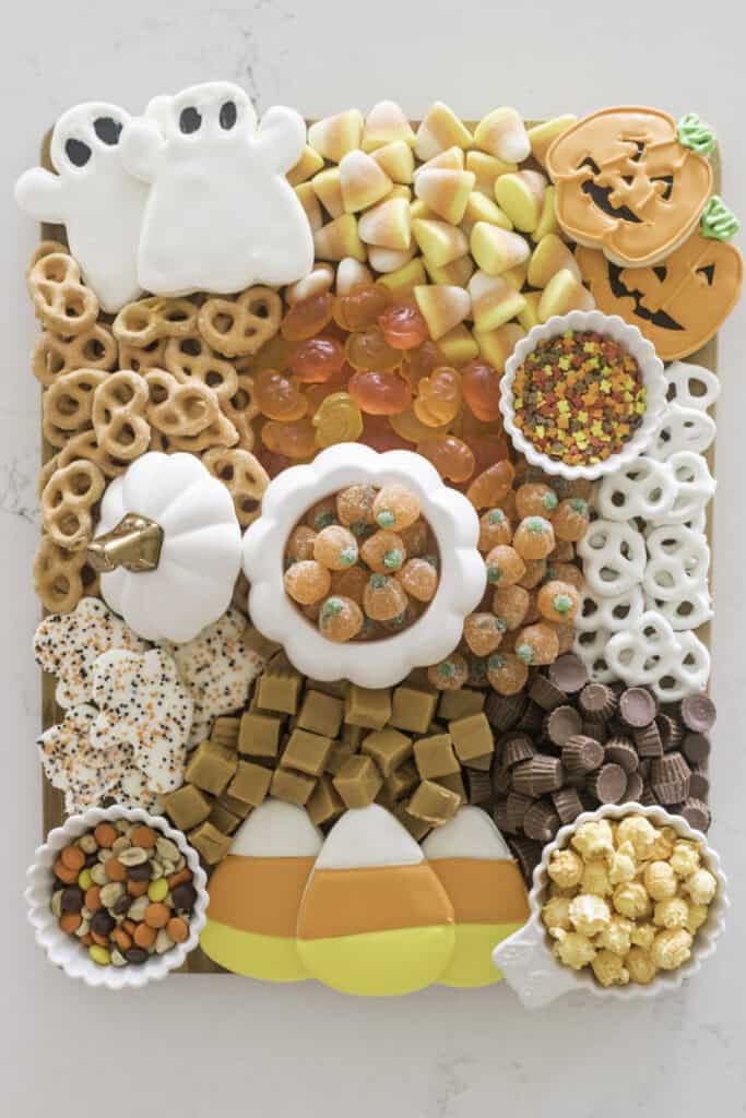 Halloween Charcuterie Board that is so festive and cute. Pumpkin cookies, ghost cookies, candies and pretzels.