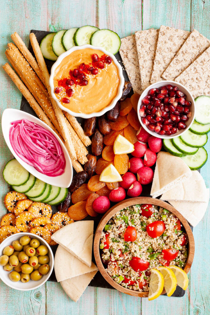 Mediterranean Grazing Board with cukes, pomegranite seeds, radishes, onions, pretzels, lemon